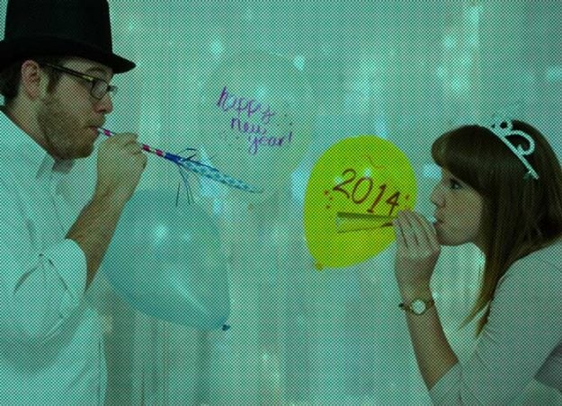 Two people blow celebratory horns brining in the 2014 new year