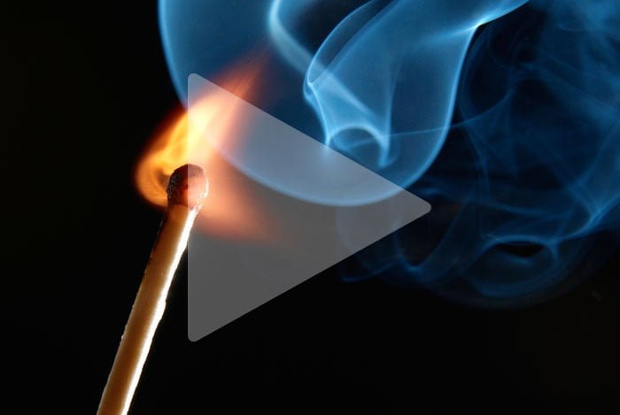 A play button over top of a lighting match