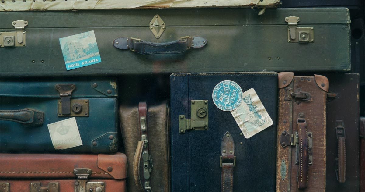 A bunch of bags and suitcases rest on each other.