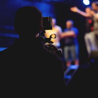 Man standing on stage holding microphone.