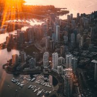 Bird s eye view of city during sunset with golden light bathing the harbour and city of Vancouver.