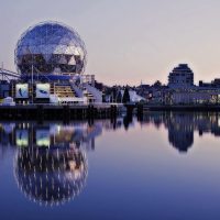 Vancouver Science World in Vancouver as seen from the water on a still blue day.