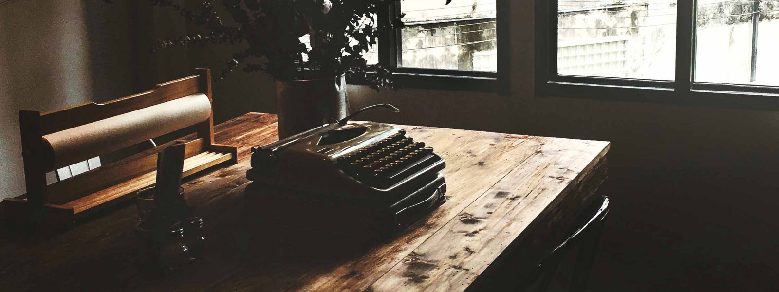 A typewriter sits on a table in the sunlight